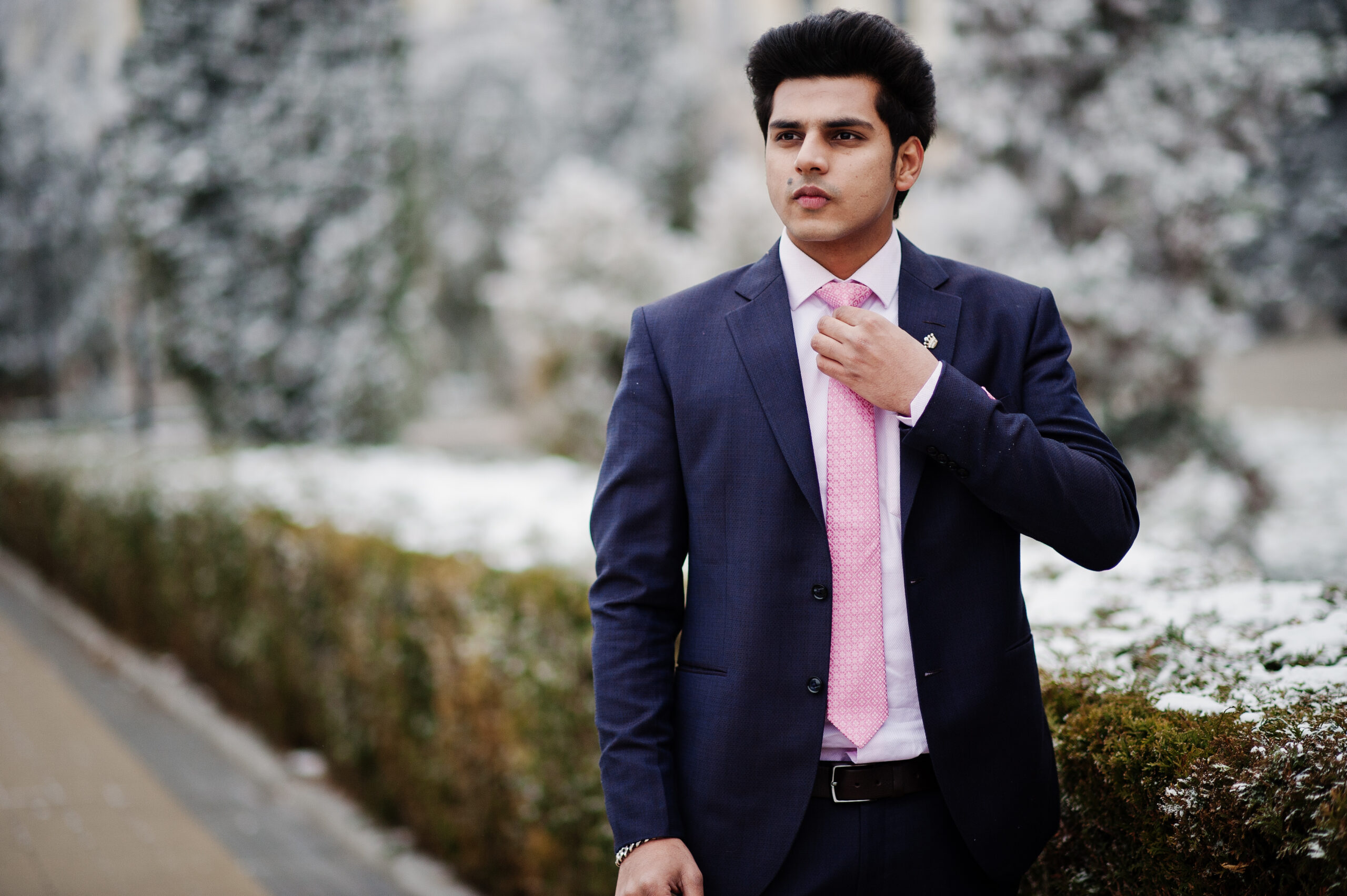 Elegant indian macho man model on suit and pink tie posed on winter day.